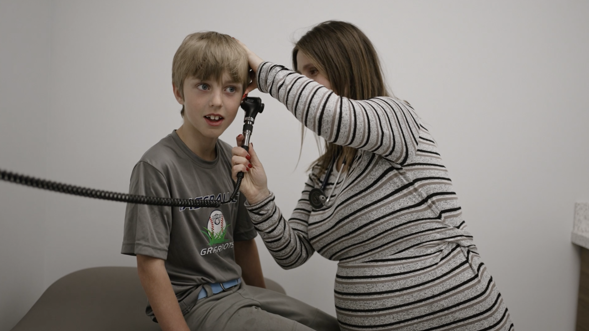 doctor checking young patient ear