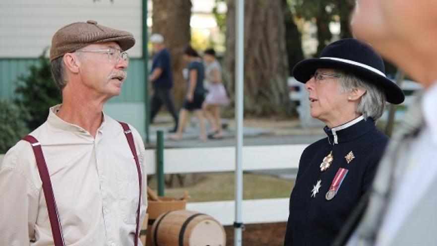 Elderly man and woman dressed in old-timey clothes.