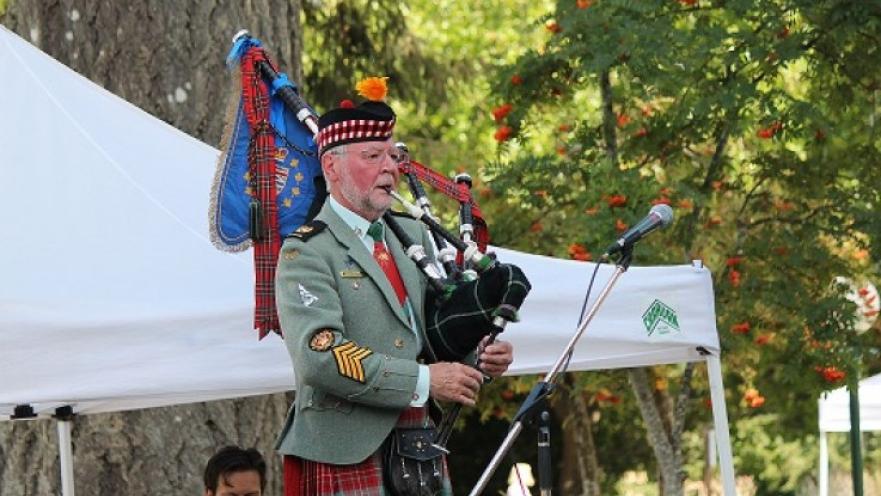 Bag piper playing the bagpipe. The subject is wearing ceremonial military attire.