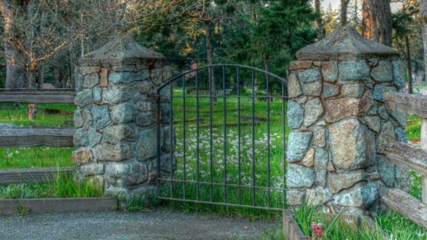 Iron gate mounted on two stonewall pillars.