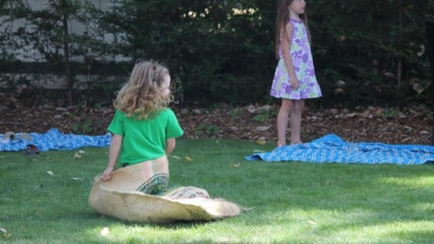 Two girls participating in a sack race. 