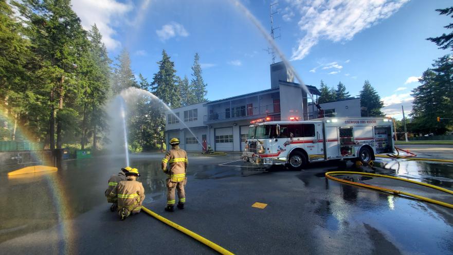 firefighters spray hoses at fire hall