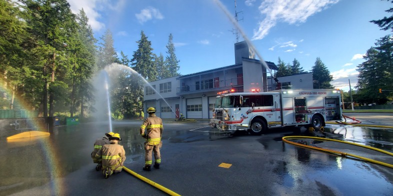 colwood firefighters spraying hoses at fire hall in the sunshine