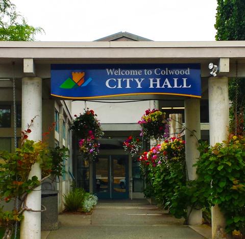 Entrance of Colwood City Hall with flowers and welcome sign.