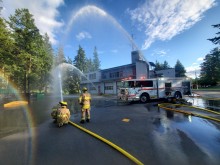 colwood firefighters spraying hoses at fire hall in the sunshine