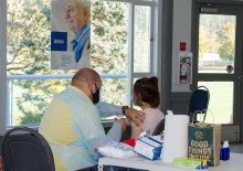 pharmacist administering flu vaccine to young girl