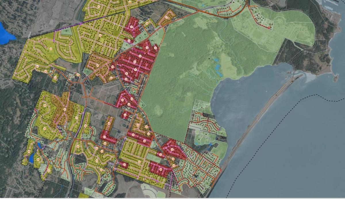 Color-coded map of a coastal area, showing various land use zones with residential and commercial developments in yellow, red, and green. The map includes roads, forests, and a large body of water on the right.