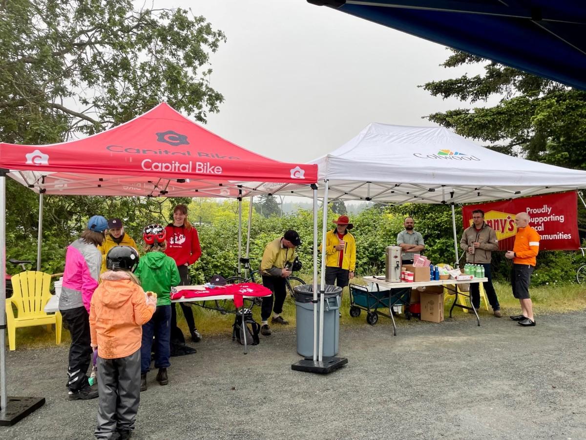 Outdoor event setup with tents and people gathered at a biking event.